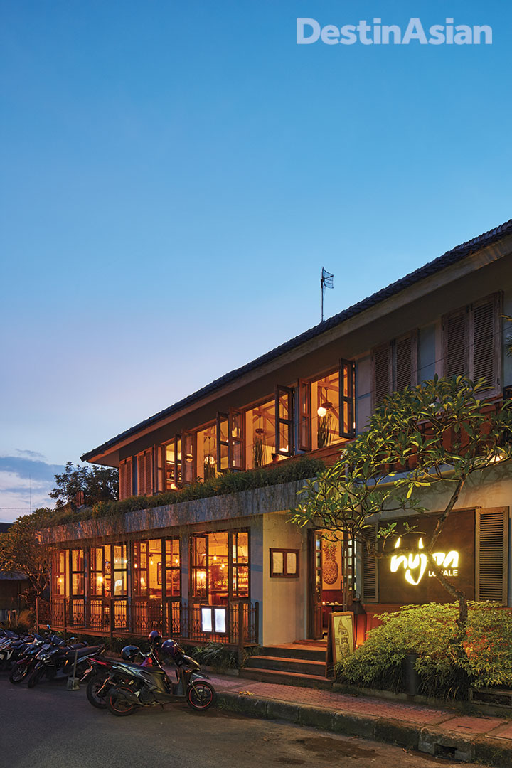 The exterior of Hujan Locale restaurant at dusk. 