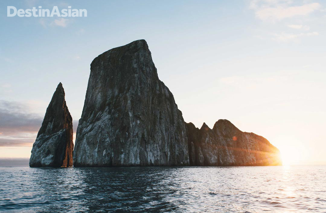 The sun setting behind Kicker Rock off San Cristóbal. The remnant of a volcanic cone, this iconic formation is also known by the Spanish name León Dormido because it resembles a sleeping lion when viewed from the south.
