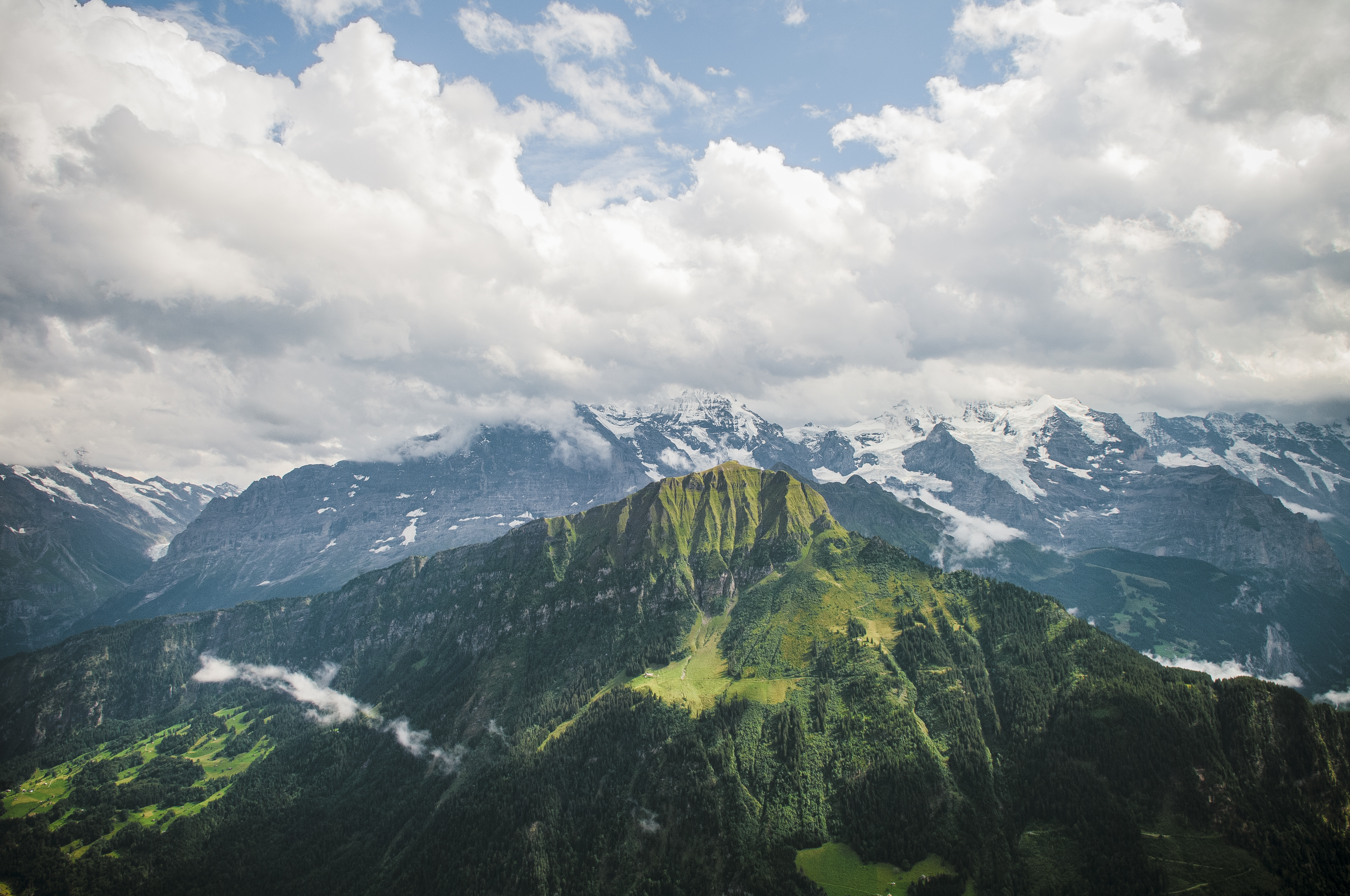 The glaciers and rock faces of the Jungfrau massif are a stark contrast to the forested slopes of nearby Männlichen, a 2,343-meter peak.