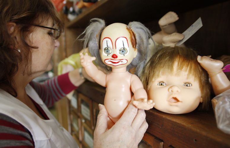 One of the "doctors" of the Hospital de Bonecas, reviewing a doll that is to be repaired. 