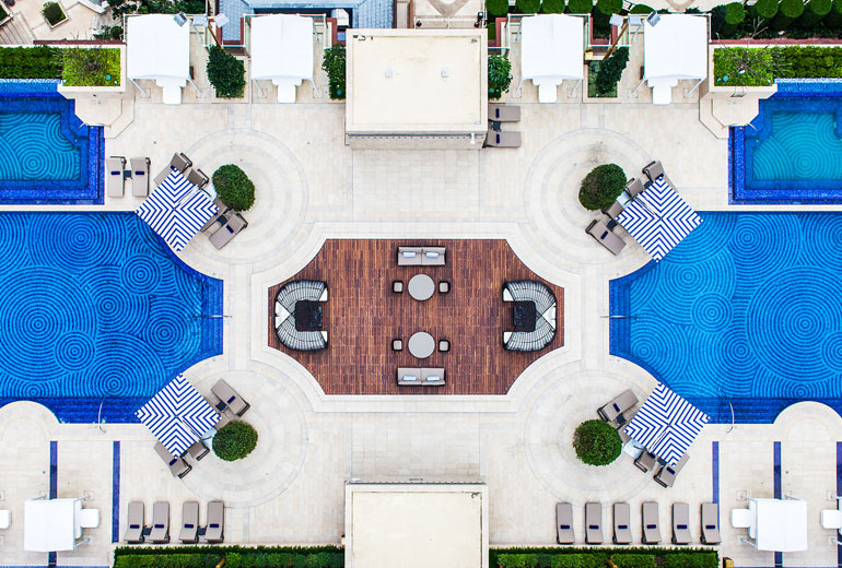 A bird's eye view of the hotel's outdoor swimming pool area.