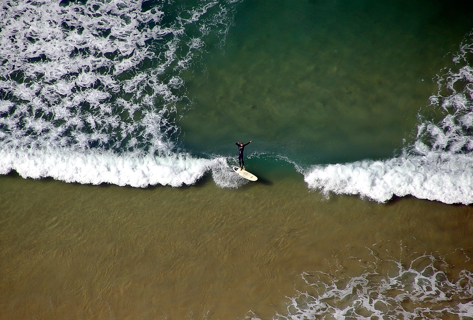 Bird's eye view of a surfer catching the waves.