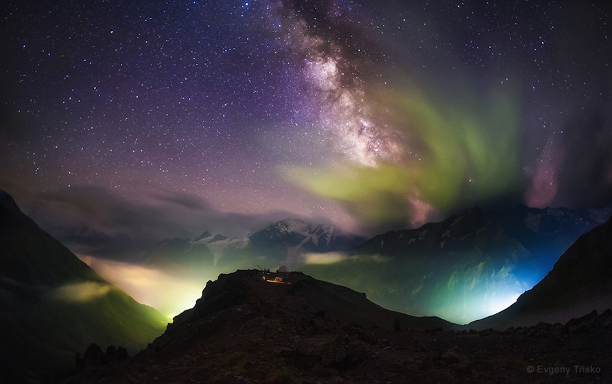 'Above the Light Pollution' by Evgeny Trisko (www.vk.com/trisko_foto). The Milky Way emerges from the clouds over lights in the valley. In the center is the Peak Terskol Observatory near Mt. Elbrus, northern Caucasus Mountains, Russia, photographed in August 2014. The 2nd winner in the Against the Lights category.
