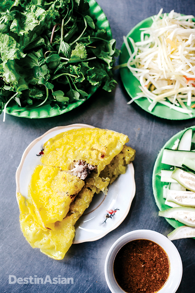A banh xeo shrimp pancake filled with pork, bean sprouts, and fresh herbs served here at Banh Xeo Ba Duong.