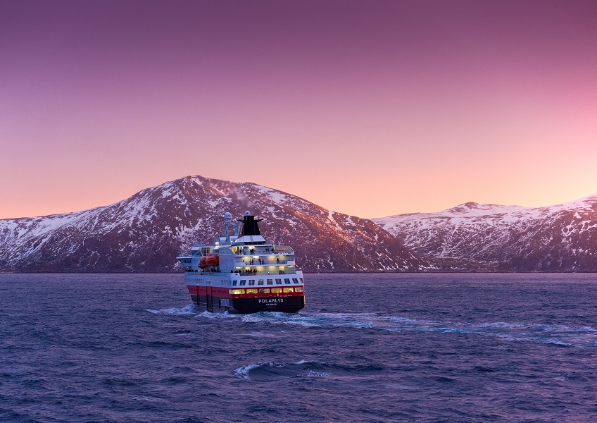 Hurtigruten's Astronomy Voyage ship passes under a sky lit up by the lights (photo credit: John Jones).