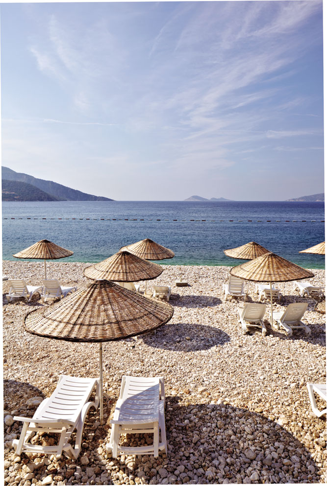 Woven-rush umbrellas shade sun loungers at Kalkan, an old Ottoman-Greek village that has emerged as the ideal base for exploring Turkey's Lycian coast.