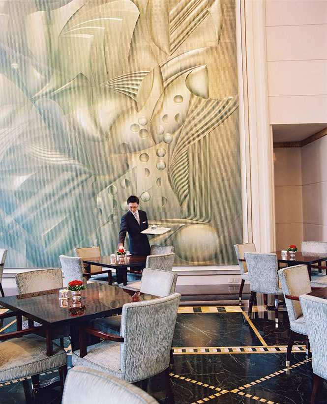Preparing for high tea in the soaring lobby of Shanghai’s Peninsula hotel.