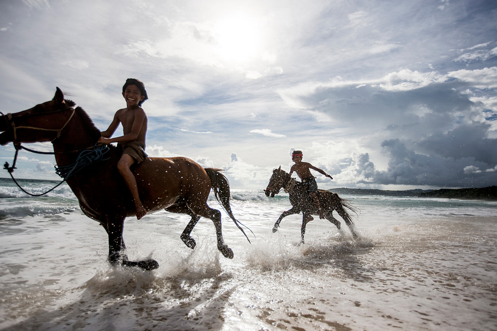 Village boys galloping through the surf.