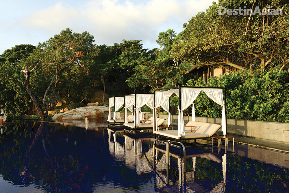 Canopied daybeds flank the swimming pool at Vana Belle.