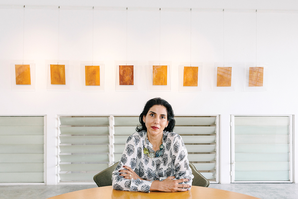 Shalini Ganendra, founder of SGFA, backed by a row of works from Bibi Chew.